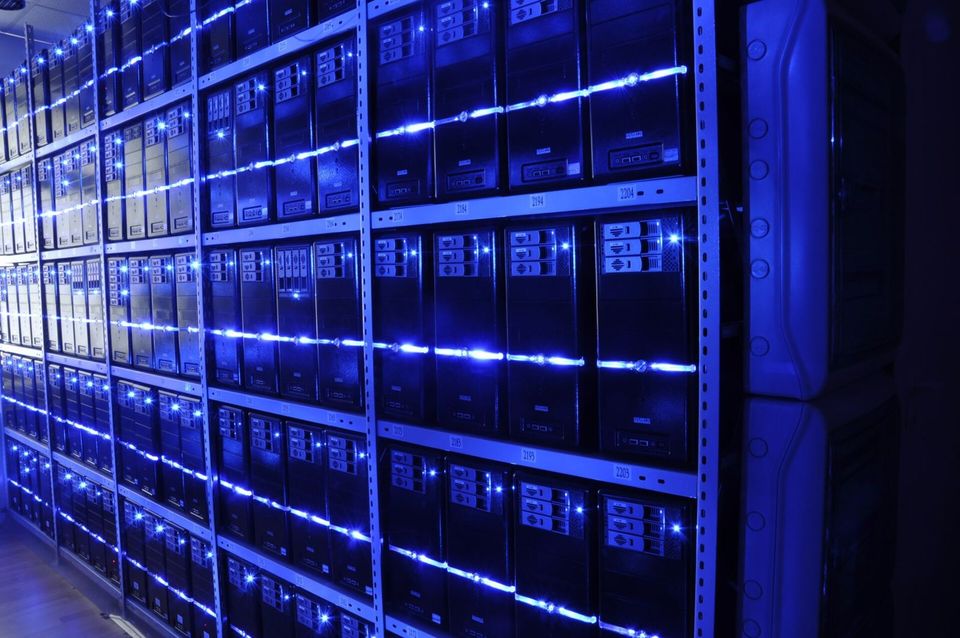Rows of server racks lit with blue light in a data centre