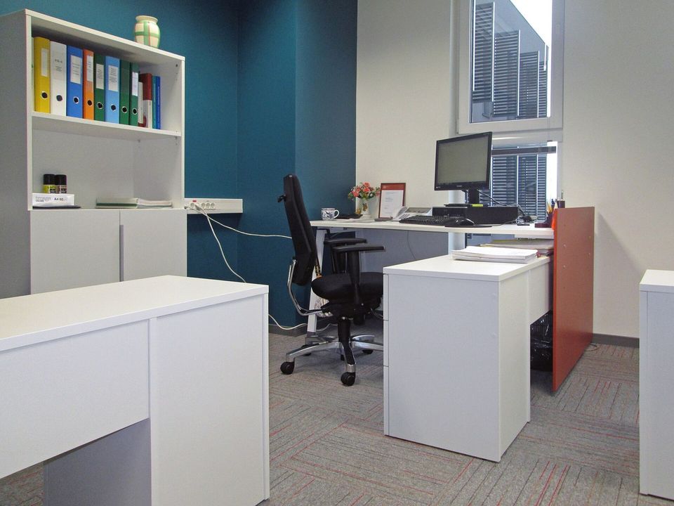Bright modern office with desks and shelving