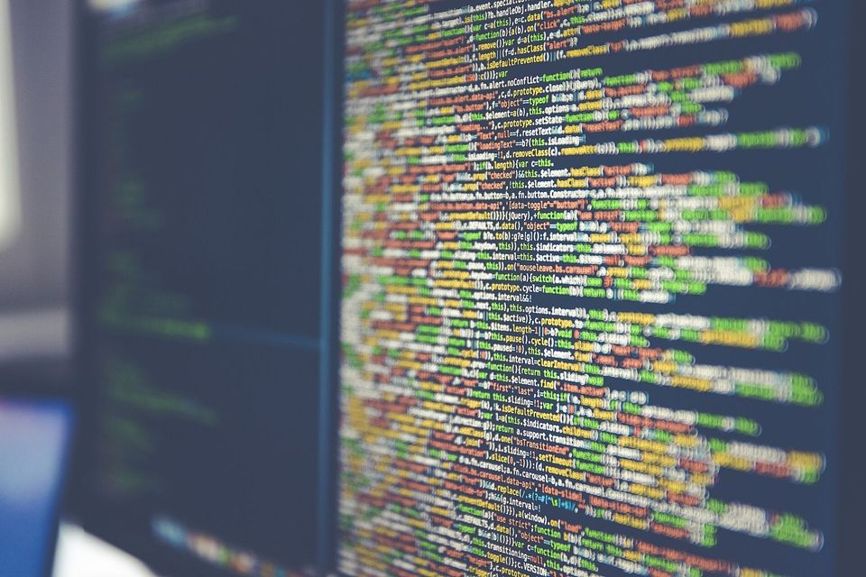 Monitor filled with colourful lines of source code