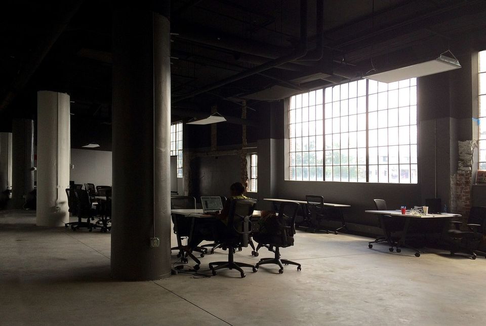 Empty open-plan loft office with large windows