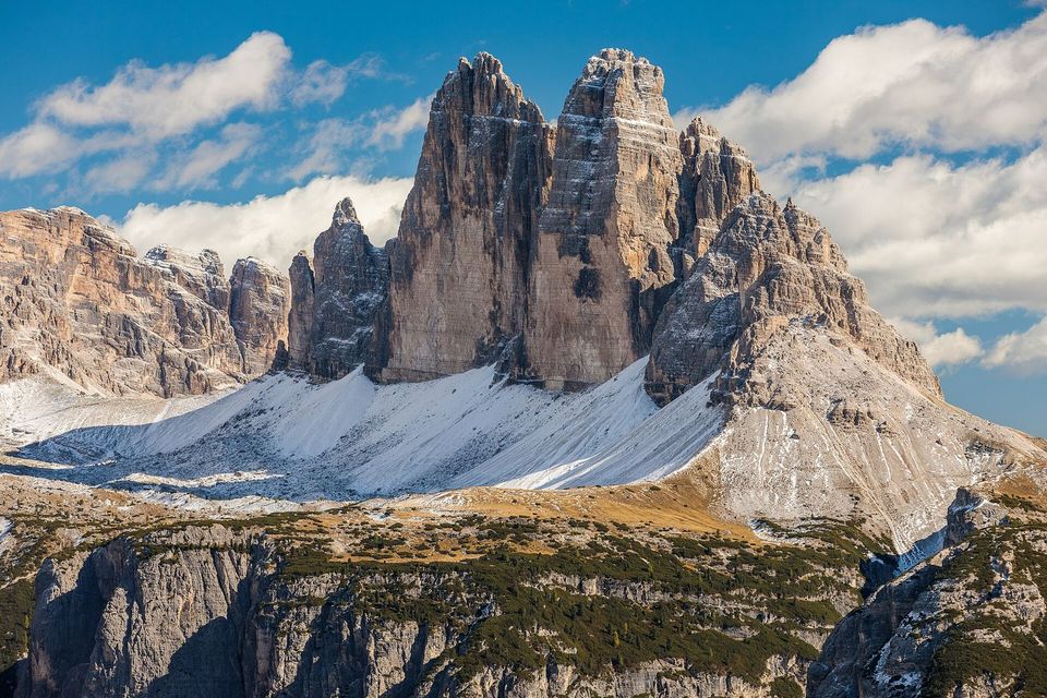 The three peaks of Tre Cime di Lavaredo above scree slopes and snow