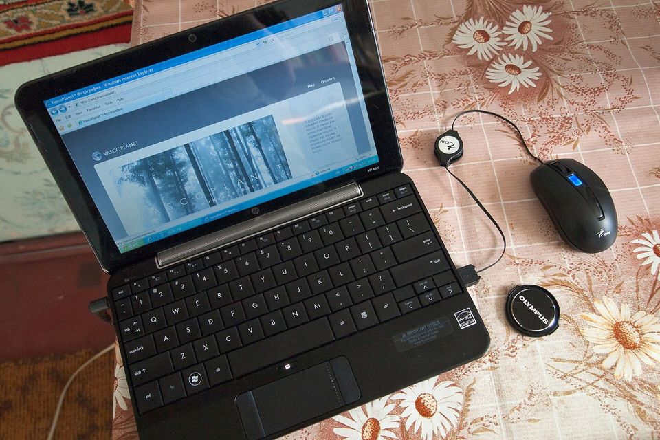 Laptop showing a spreadsheet beside a notebook and calculator